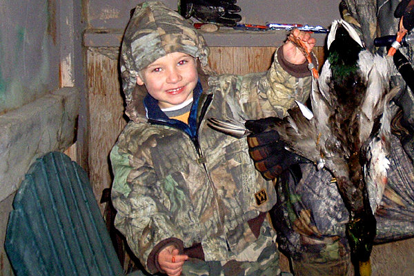 Grandson Brett when 5 years old with his $100 duck.  His first thoughts were "Grandpa, you had me shoot someones pet, he has bracelets on both legs"