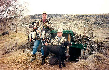 Two years after the previous picture Bryce (age 18) & Bob Farris (also at a much younger age) with 2 year old Cedarwoods Icelus (Ice) on a Snake River duck hunt in the Hagerman Valley in the same blind.  How time passes; Bryce is now an attorney practicing water law and many times in this water rich valley of Idaho.